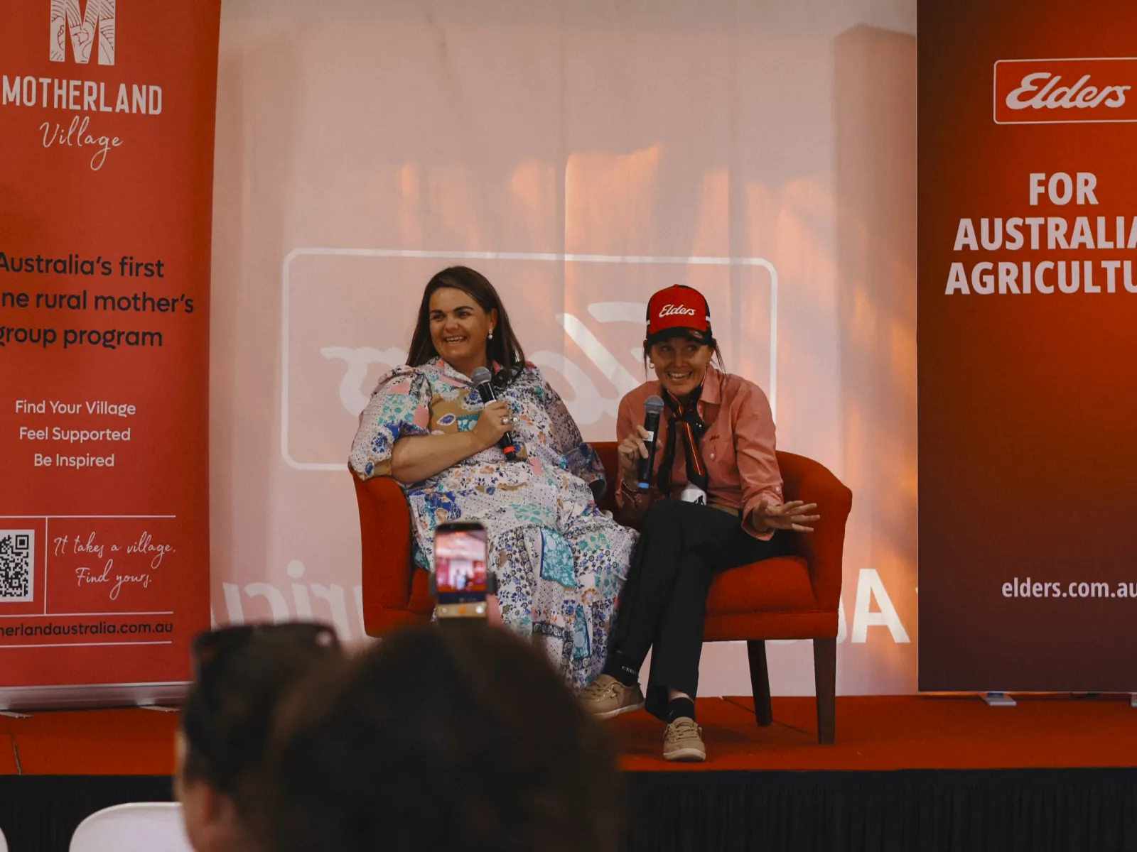 Panel conversation at a Motherland Village event with corporate partner branding