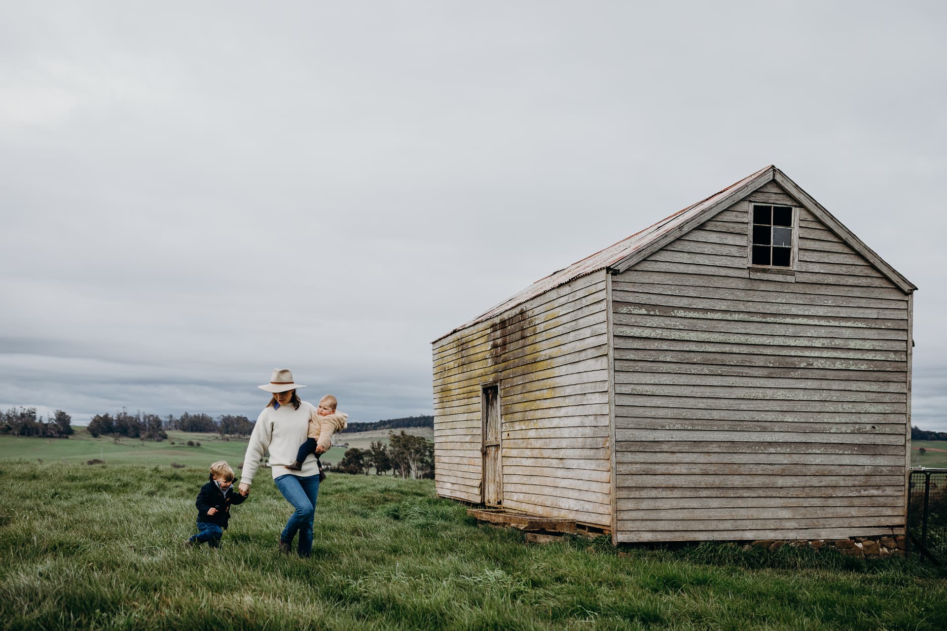Stephanie Trethewey walking through a paddock with her two children