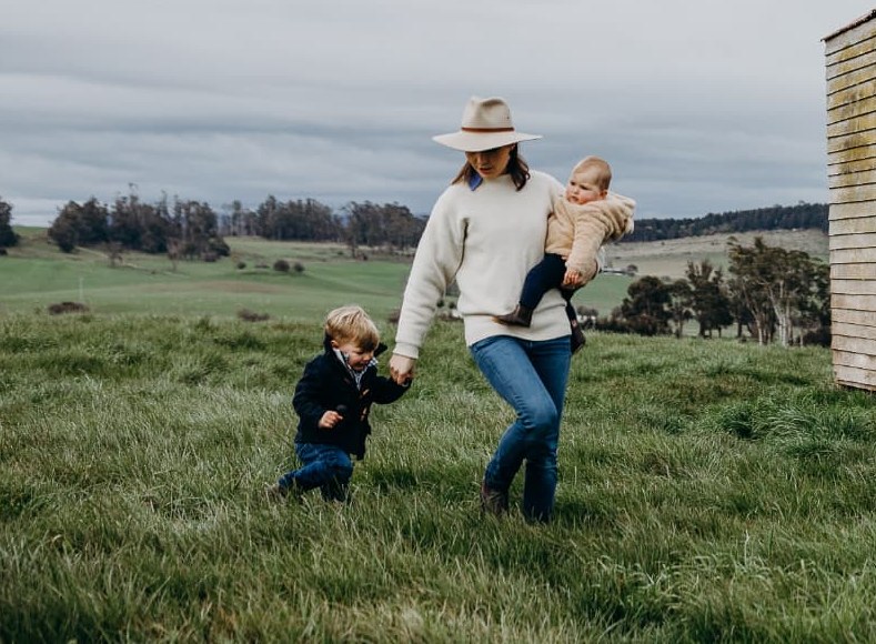 Stephanie Trethewey walking through a paddock with her two children